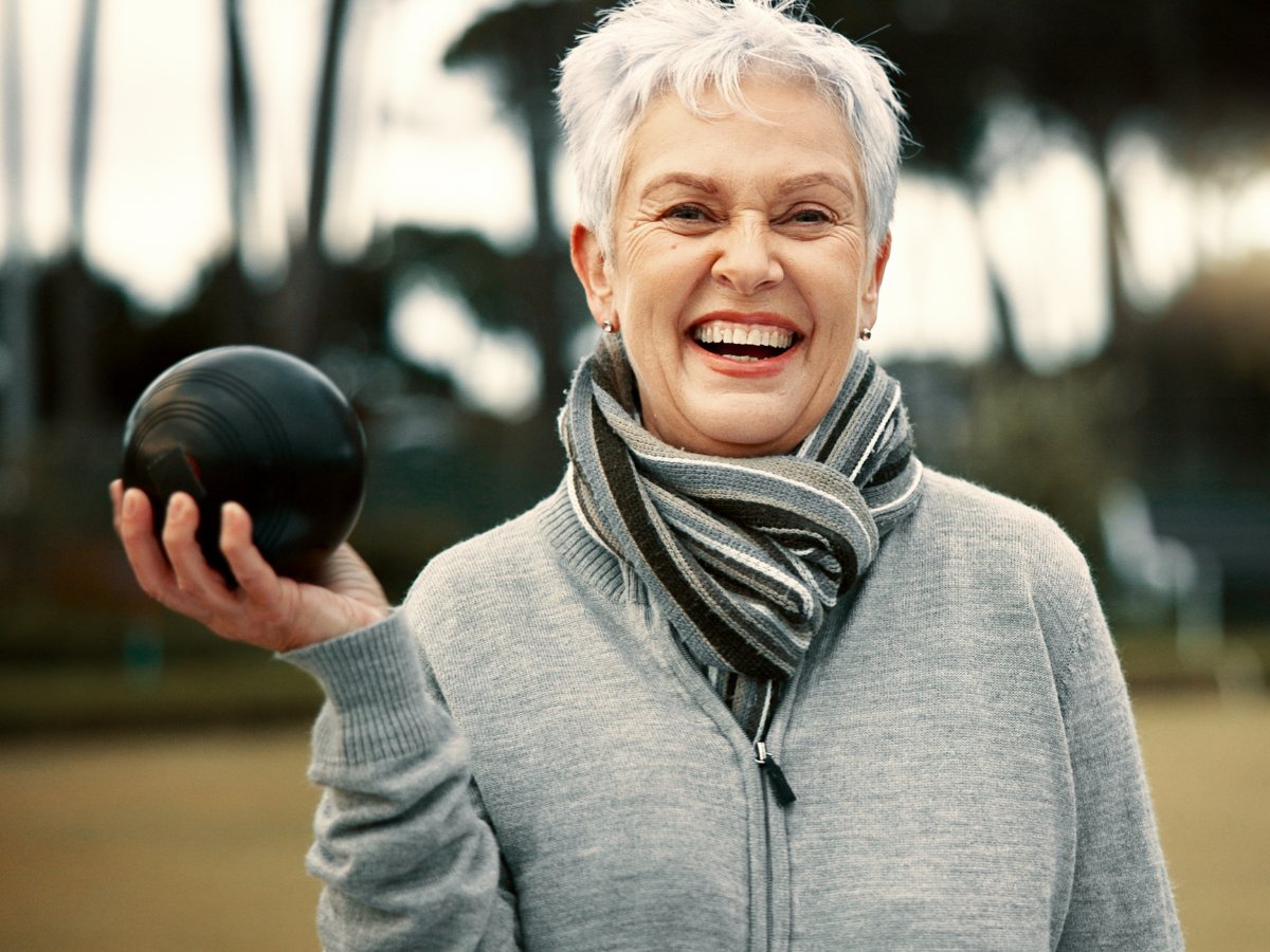 Lawn bowling player smiling with bowl in hand